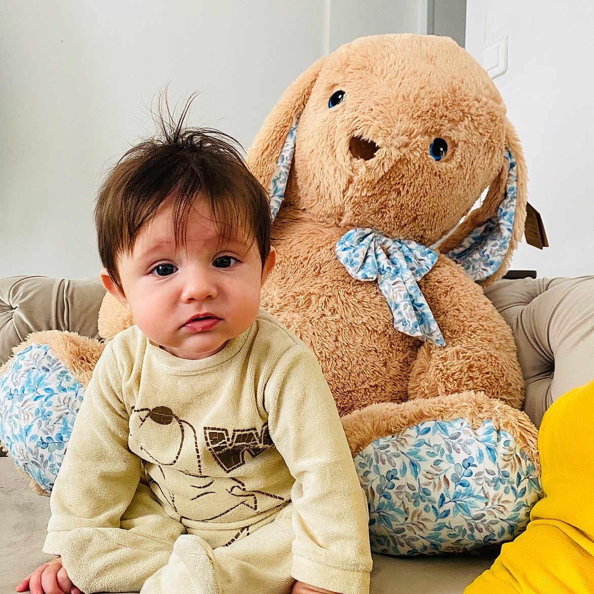 Shayan a rejoint le concours — aidez-le/la à gagner de superbes lots ! baby, bunny, child, couch, curious, decor, expression, face, fur, hand, home, indoor, onesie, person, plush_toy, seated, soft_toy, stuffed_animal, toddler, yellow_clothing