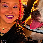 Freja And Athena is registered to the contest to win money with this photo: car, close_up, collar, companion, dog, golden_hour, harness, long_hair, makeup, outdoor, pet, pit_bull, portrait, seat, selfie, smiling, sunset, tongue_out, vehicle, woman
