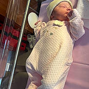 Louna a rejoint le concours — aidez-le/la à gagner de superbes lots ! newborn, baby, sleeping, hospital, bassinet, pink_onesie, knitted_cap, infant, soft_lighting, blanket, cute, peaceful, person, bed, fabric, rest, small_hands, indoor, cozy, portrait