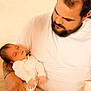 baby, man, sleeping, beard, white_clothing, indoor, holding, person, family, parent, love, tender, infant, closeup, portrait, gentle, rest, warm_light, skin, care