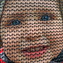 child, face, netting, mesh, red_jacket, eyes, portrait, curious, outdoor, clothing, young, expression, closeup, texture, headwear, person, winter, warm_clothing, black_mesh, background_blur