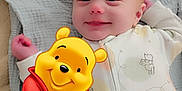 Titan is registered to the contest to win money with this photo: baby, smiling, blanket, onesie, cartoon, winnie_the_pooh, character, digital_art, cute, lying_down, infant, soft_texture, child, happy, bedtime, toddler, illustration, playful, portrait, cozy