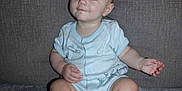 Titan joined the competition — help win amazing prizes! baby, child, infant, onesie, couch, gray, sitting, cute, face, skin, foot, hand, expression, young, indoors, smile, person, head, leg, blue