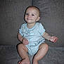 baby, child, infant, onesie, couch, gray, sitting, cute, face, skin, foot, hand, expression, young, indoors, smile, person, head, leg, blue