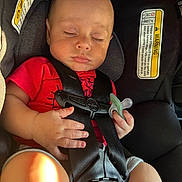Colton joined the competition — help win amazing prizes! baby, sleeping, car_seat, pacifier, red_shirt, child, infant, seat_belt, safety, resting, cute, hands, clothing, indoors, young_child, peaceful, portrait, car_interior, warning_label, closeup