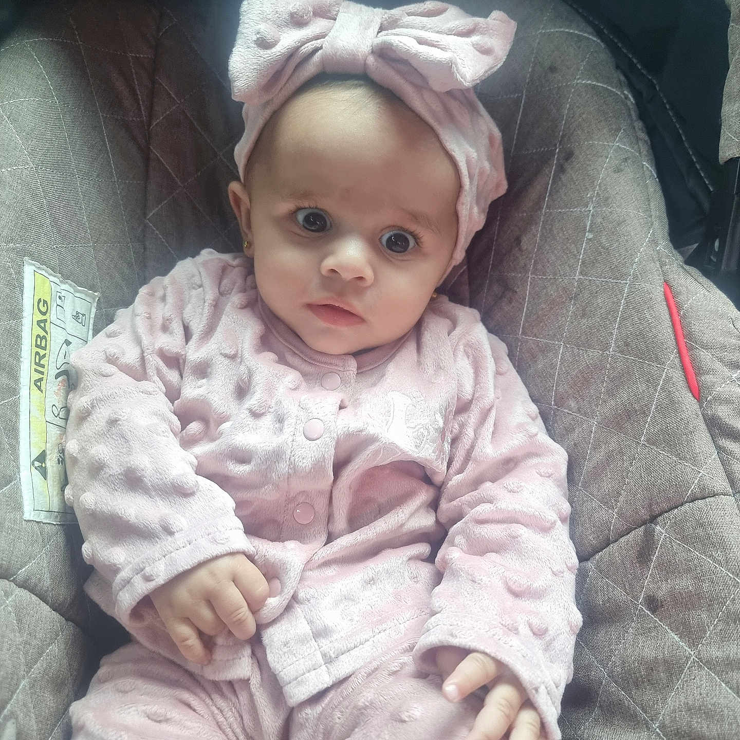 Vivien joined the competition — help win amazing prizes! adorable, baby, bow, car_seat, child, clothing, cozy, cute, expression, face, hand, headband, indoors, infant, person, pink_clothing, portrait, seated, soft_texture, young_child