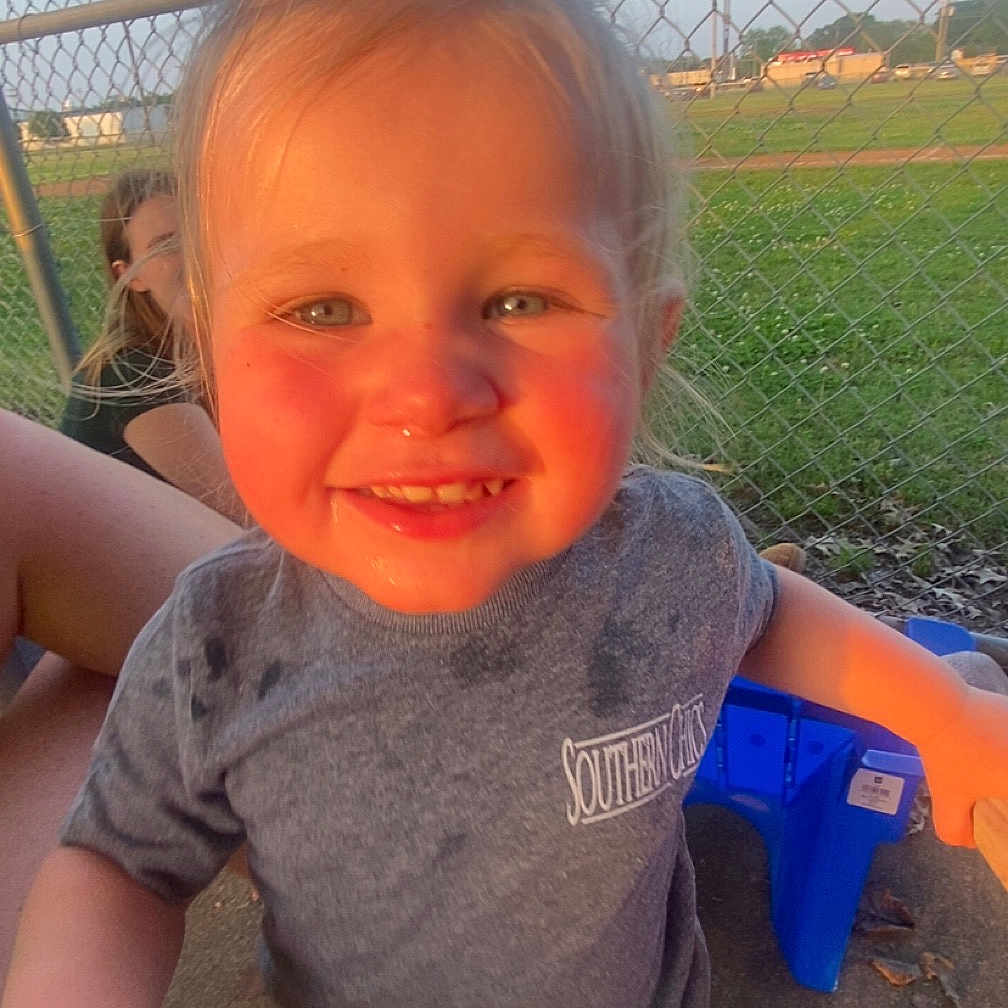 Everleigh is registered to the contest to win money with this photo: baby, bodypart, child, clothing, face, female, fence, girl, grass, head, mouth, outdoors, person, photography, plant, playarea, portrait, summer, t_shirt, teeth