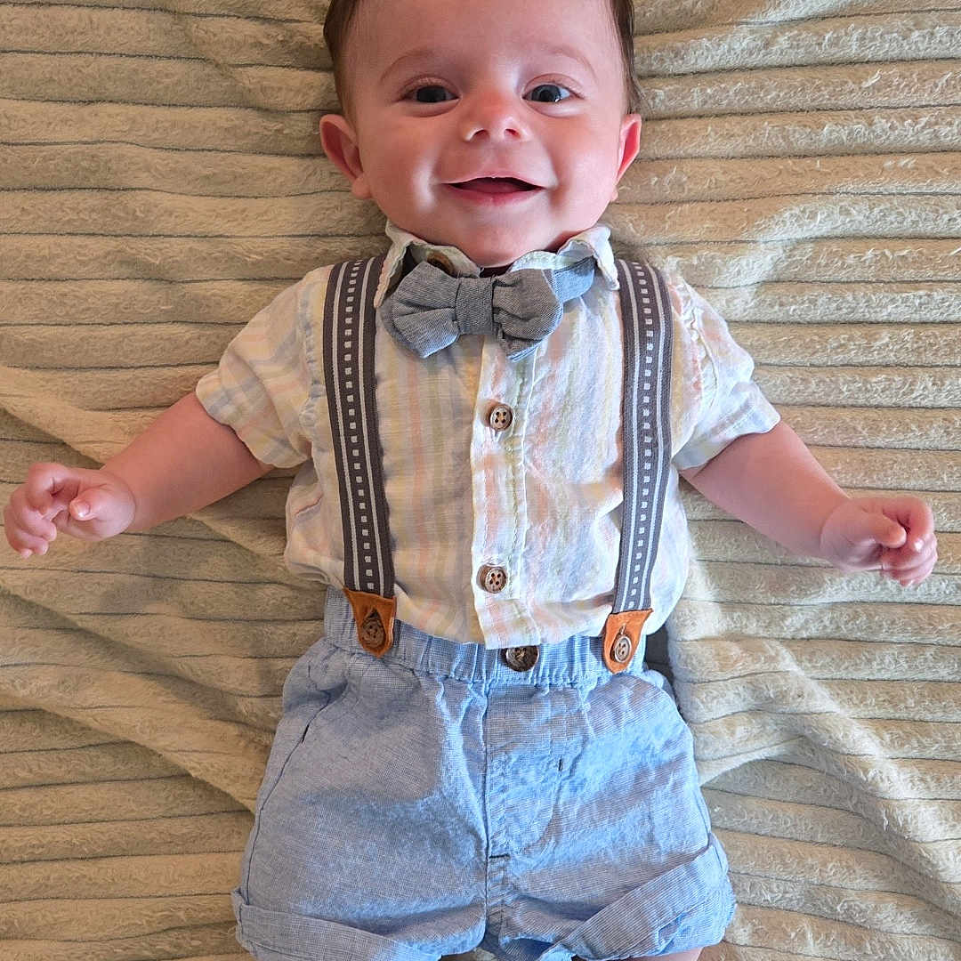 Lyon is registered to the contest to win money with this photo: accessories, baby, bodypart, clothing, face, finger, formalwear, hand, head, jeans, pants, person, photography, portrait, shirt, shorts, skirt, strap, suspenders, tie