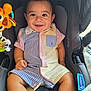 baby, infant, child, smiling, car_seat, seat, toy, striped_clothing, pocket, happy, face, eyes, legs, hands, safety_harness, stroller, cute, portrait, button_up_shirt, canopy