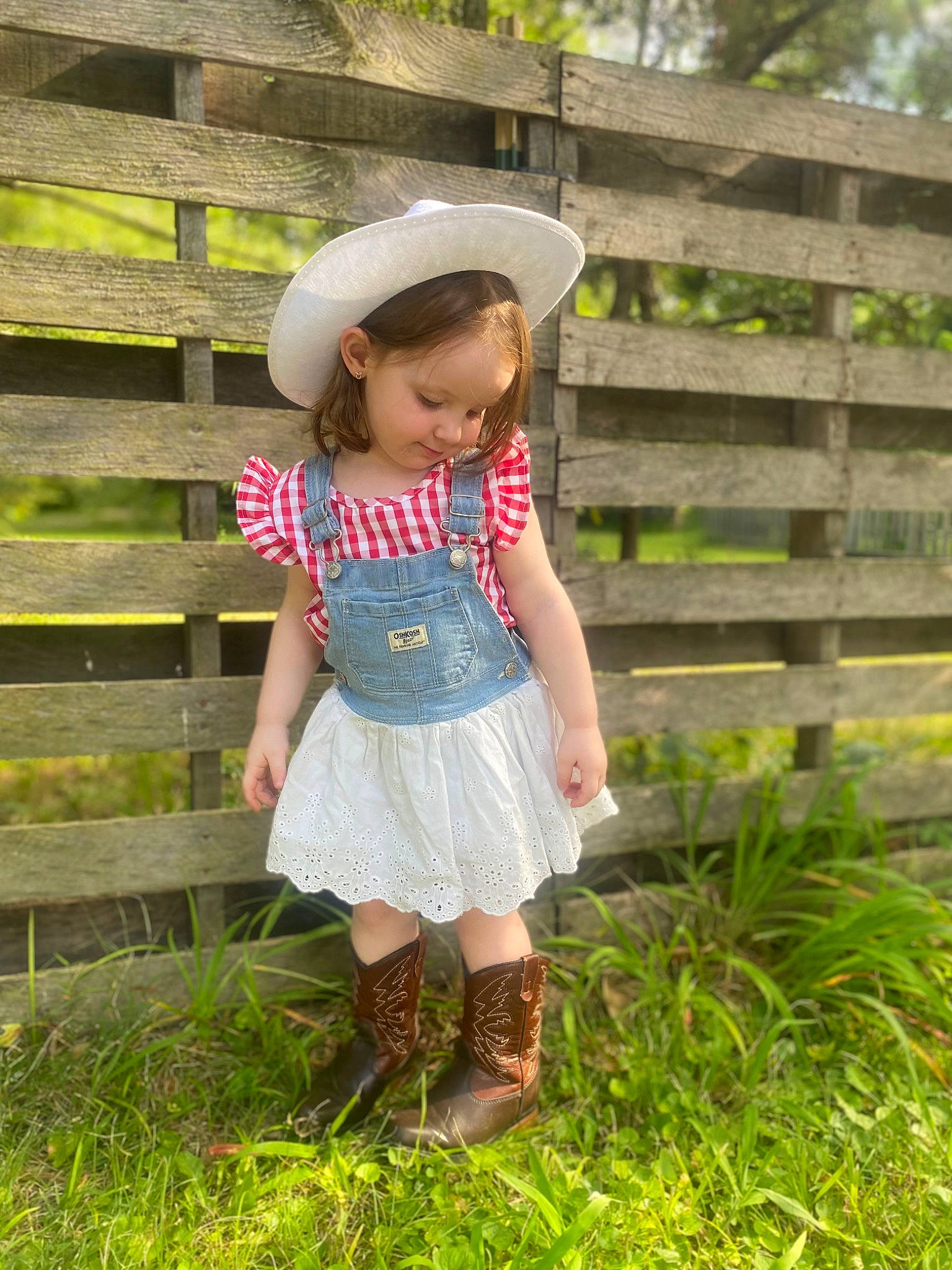 Esme joined the competition — help win amazing prizes! baby_toddler_clothing, botany, fence, grass, grass_family, grassland, happy, hat, landscape, leisure, mammal, meadow, people_in_nature, person, plant, rural_area, shorts, standing, sun_hat, toddler