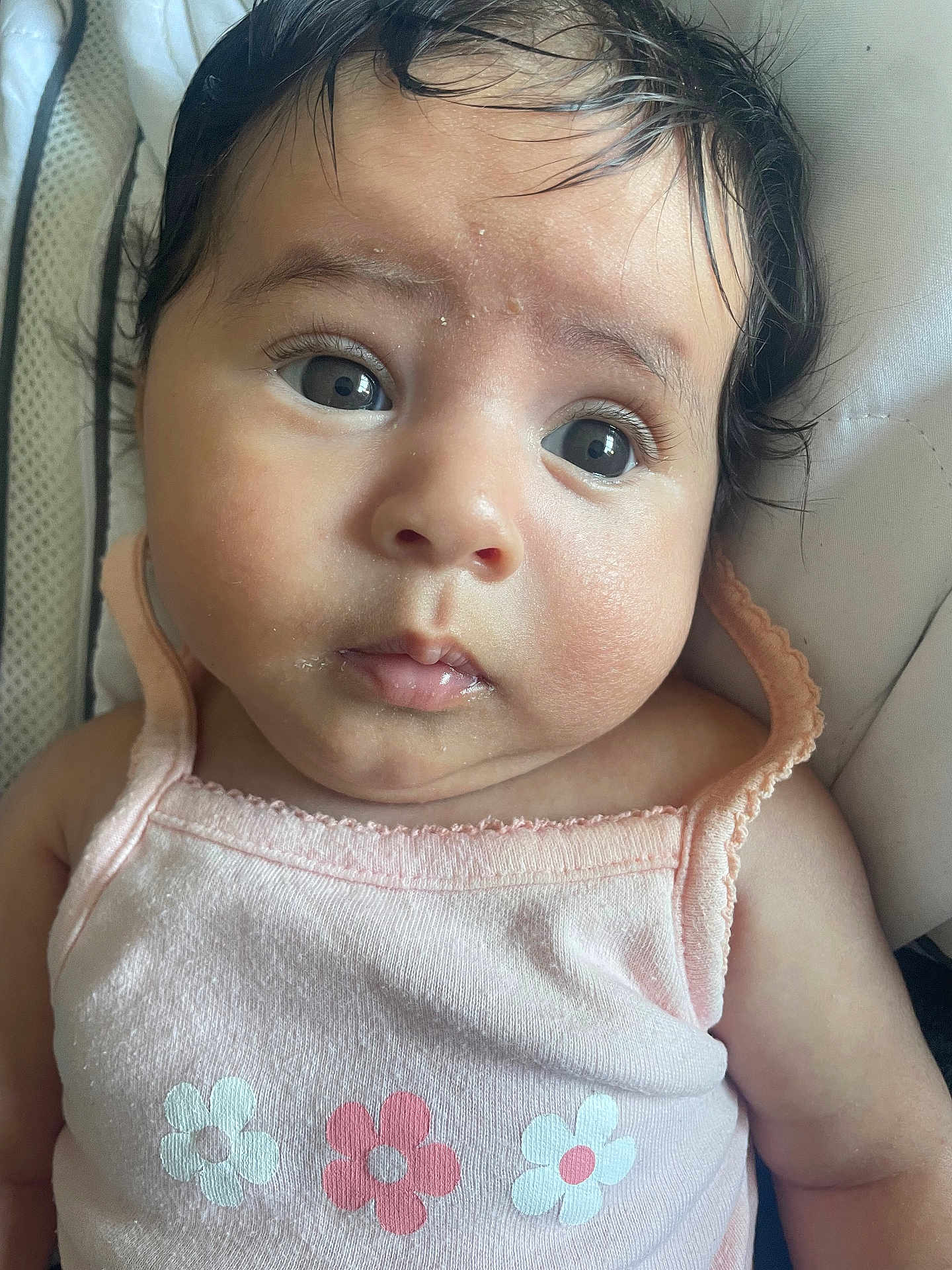 Sofia a rejoint le concours — aidez-le/la à gagner de superbes lots ! baby, infant, face, eyes, pink_clothing, tank_top, flower_print, cute, child, skin, hair, closeup, portrait, young, resting, indoors, cushion, expression, curious, person