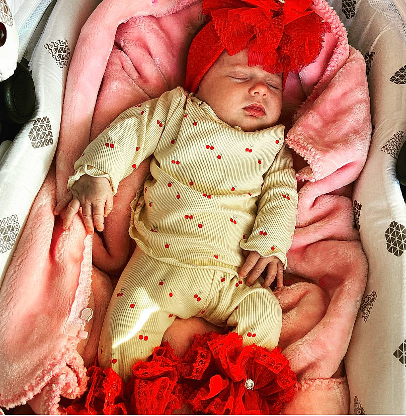 Amber participe au concours pour gagner de l'argent avec cette photo : abdomen, arm, baby, baby_safety, baby_sleeping, baby_toddler_clothing, cheek, child, comfort, face, gesture, hand, head, headwear, leg, mouth, person, pink, red, skin