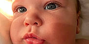 Bradley is registered to the contest to win money with this photo: baby, close_up, face, blue_eyes, chubby_cheeks, skin, lips, natural_light, infant, cute, portrait, child, newborn, expression, soft_skin, eyelashes, head, healthy, indoors, young