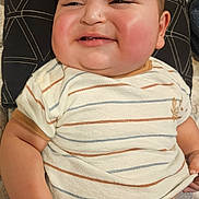 Moisés joined the competition — help win amazing prizes! baby, child, smiling, striped_shirt, pillow, indoor, cheeks, shorts, face, cute, infant, resting, hand, comfort, person, young_child, head, skin, portrait, happy