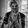 animal, black_and_white, casual_clothing, cat, curious, domestic_cat, eyes, face, feline, hand, holding, home, indoor, person, portrait, short_hair, stripes, tabby_cat, tattoo, window