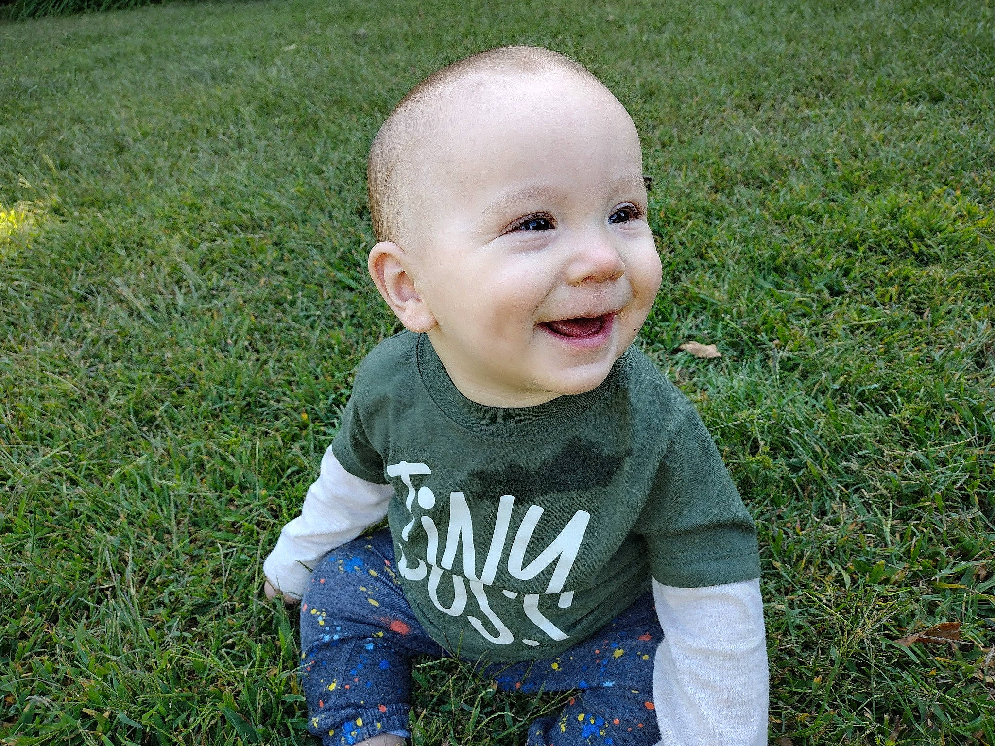 Gideon joined the competition — help win amazing prizes! baby, baby_laughing, baby_toddler_clothing, child, eye, fun, grass, grass_family, grassland, hair, happy, head, leisure, mammal, meadow, people_in_nature, person, plant, smile, t_shirt