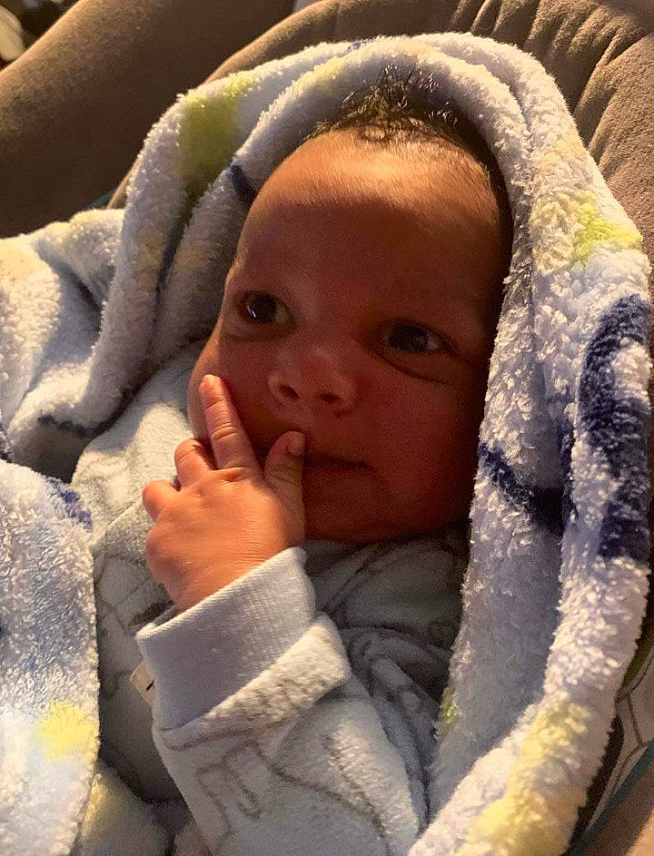 Jaxston is registered to the contest to win money with this photo: baby, baby_toddler_clothing, cheek, comfort, ear, eye, eyebrow, face, facial_expression, finger, gesture, head, linens, lip, mammal, mouth, nose, person, skin, textile