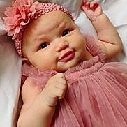 Azira is registered to the contest to win money with this photo: baby, infant, pink_dress, headband, flower, cute, smile, face, skin, hand, lying_down, soft, white_background, portrait, child, adorable, close_up, young, tulle, fabric