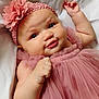 baby, infant, pink_dress, headband, flower, cute, smile, face, skin, hand, lying_down, soft, white_background, portrait, child, adorable, close_up, young, tulle, fabric