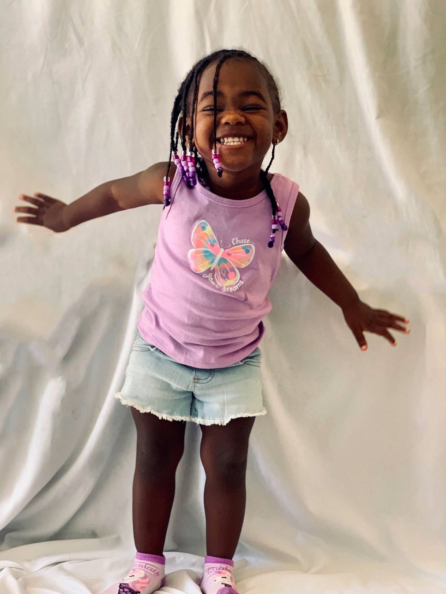 Jasiri is registered to the contest to win money with this photo: arm, cheek, child, face, facial_expression, fun, happy, head, joint, joy, people, person, pink, play, purple, shoulder, skin, smile, standing, t_shirt