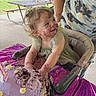 toddler, child, cake, birthday_cake, purple_frosting, high_chair, outdoor, party, messy, happy, smiling, food, celebration, table, person, curly_hair, face_paint, dirt, playful, fun