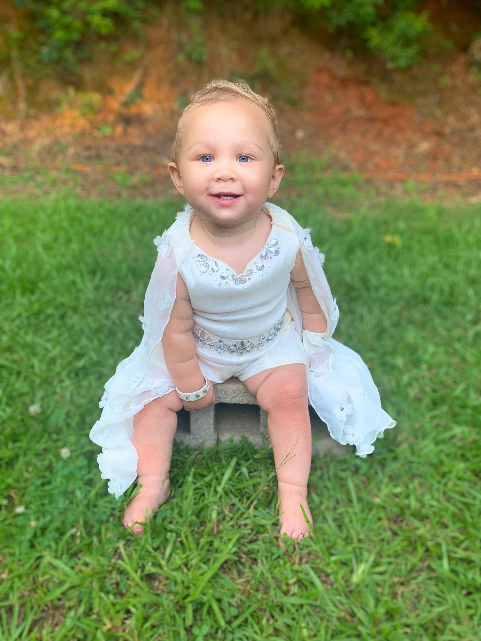 Ava joined the competition — help win amazing prizes! baby, baby_toddler_clothing, barefoot, cheek, dress, eye, face, flash_photography, fun, grass, grassland, happy, head, joy, meadow, people_in_nature, person, plant, sitting, sleeve
