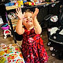 child, girl, red_dress, bubbles, indoor, toy, play, smile, happy, floor, table, snacks, blanket, chair, bottle, television, socks, wood_floor, furniture, person