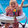 baby, child, smiling, happy, baby_walker, toy, pool, outdoor, summer, romper, pink, blue, wooden_floor, playful, infant, raising_hands, cute, person, sitting, sunlight