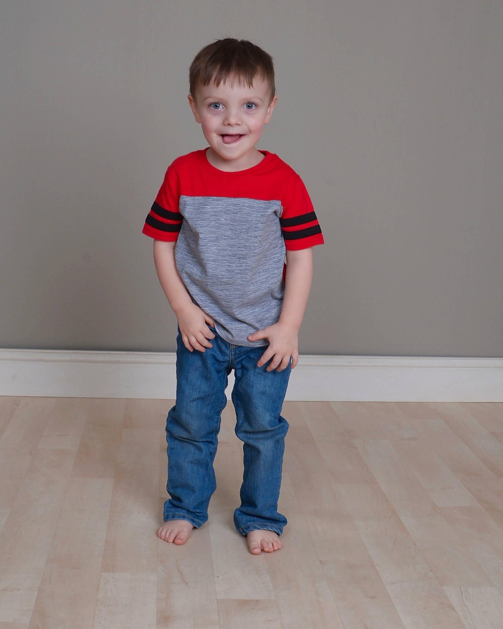 Zander is registered to the contest to win money with this photo: baby_toddler_clothing, barefoot, collar, composite_material, denim, electric_blue, face, floor, flooring, hardwood, human_body, human_leg, jeans, joy, leg, neck, pattern, person, sleeve, t_shirt