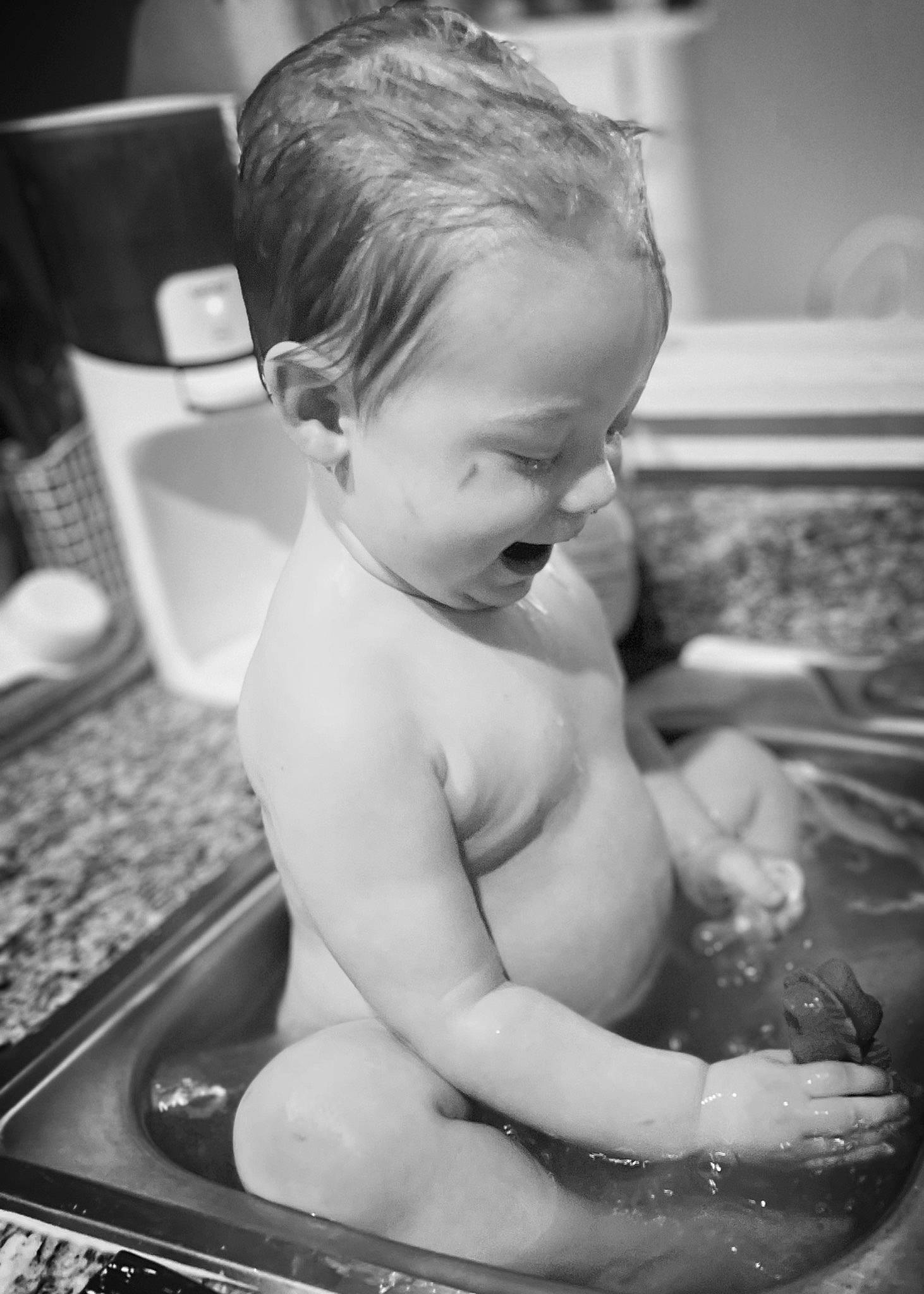 Jesse is registered to the contest to win money with this photo: arm, baby, baby_bathing, bathing, black, black_and_white, chest, eye, fluid, hairstyle, hand, happy, human_body, muscle, person, photograph, skin, style, toddler, water