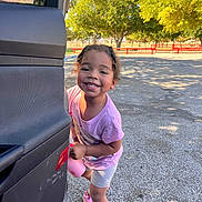 Aurora joined the competition — help win amazing prizes! car_door, child, curly_hair, daylight, happy, holding_bottle, nature, outdoor, park, pavement, person, pink_shoes, playful, purple_shirt, shadow, shorts, smiling, sunlight, toddler, trees