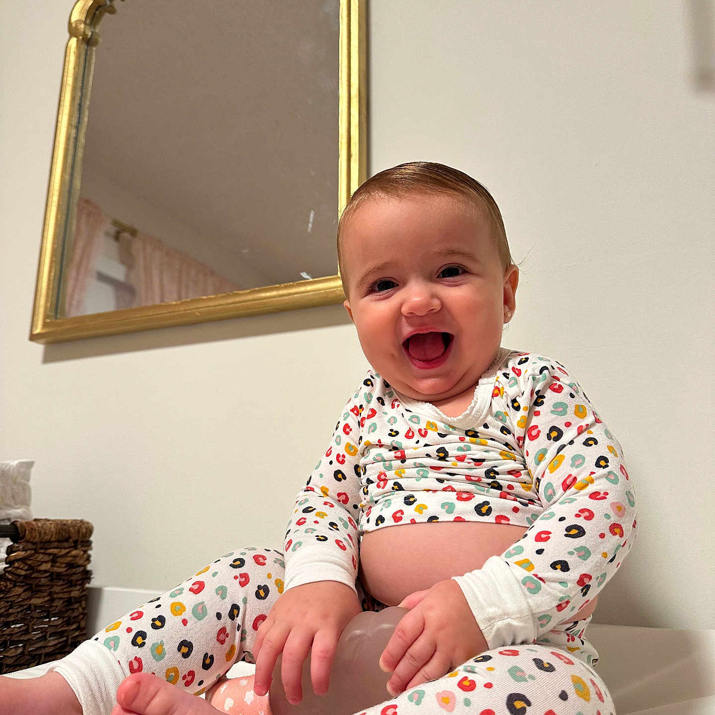 Lucia is registered to the contest to win money with this photo: baby, child, clothing, colorful, decor, face, feet, furniture, gold_frame, hands, happy, home, indoor, mirror, pajamas, person, sitting, smiling, toy, wall
