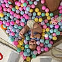 baby, child, ball_pit, colorful_balls, pastel_colors, diaper, smiling, happy, playing, legs, feet, toy, soft_toys, mesh_sides, indoor, playpen, cute, infant, joyful, relaxed
