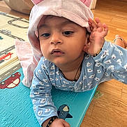 Vihaan joined the competition — help win amazing prizes! baby, child, hood, bunny_ears, blue_pajamas, bracelet, play_mat, floor, wood_floor, toy, indoor, person, cute, infant, hand, face, expression, home, carpet, curious