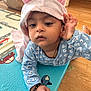 baby, child, hood, bunny_ears, blue_pajamas, bracelet, play_mat, floor, wood_floor, toy, indoor, person, cute, infant, hand, face, expression, home, carpet, curious