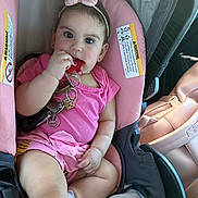 Emily Patricia is registered to the contest to win money with this photo: baby, infant, child, car_seat, keys, teething, pink_clothing, bow_headband, car_interior, warning_label, earrings, hand, legs, cute, portrait, seat, safety_strap, chewing, vehicle, playful