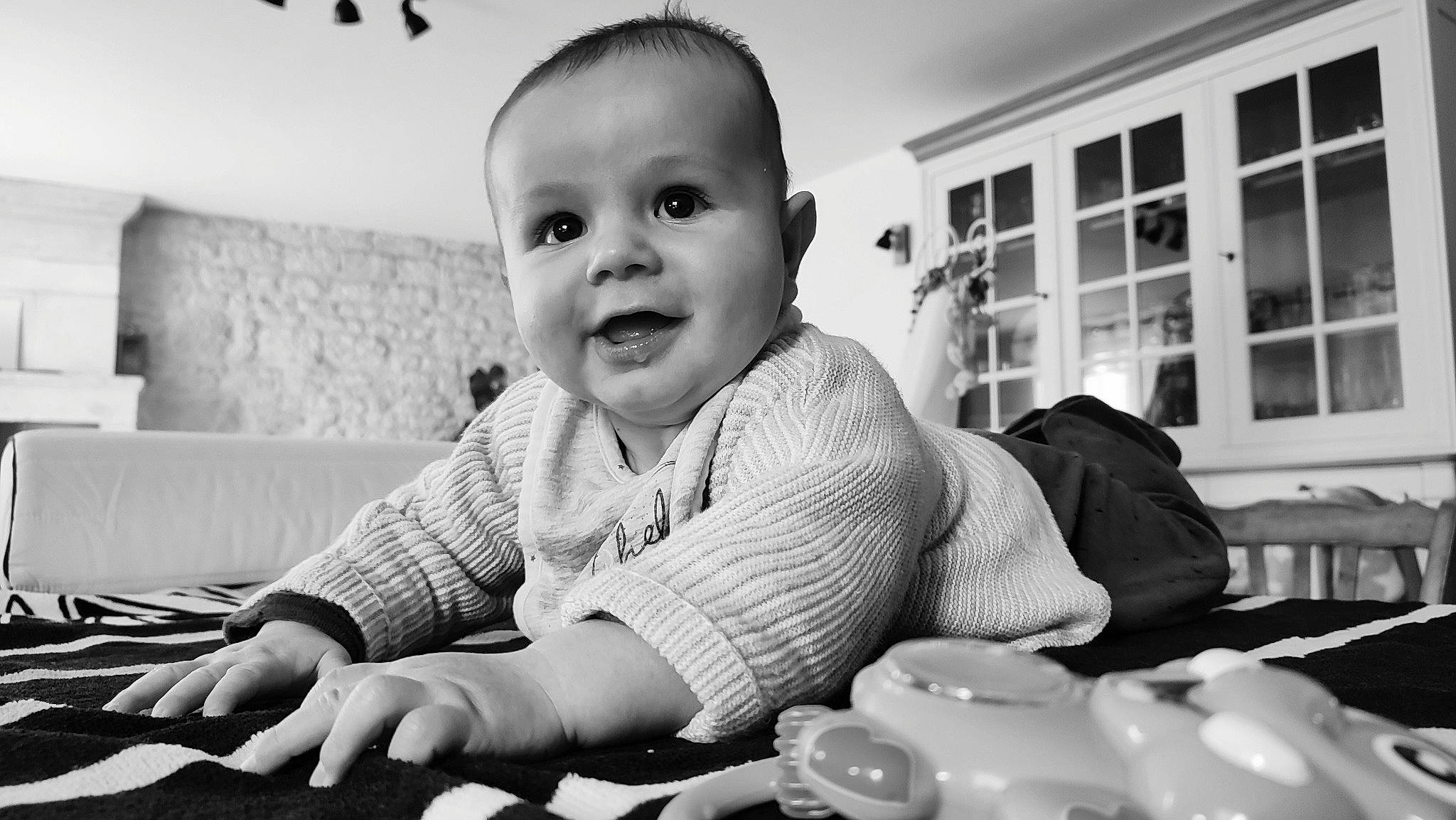 Eloan participe au concours pour gagner de l'argent avec cette photo : baby, black, black_and_white, cheek, facial_expression, finger, flash_photography, hand, happy, human, iris, organ, person, photograph, skin, smile, standing, style, toddler, white