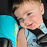 toddler, child, car_seat, seatbelt, blue_clothing, smile, face, baby, infant, young_child, portrait, straps, safety, cute, happy, indoors, closeup, skin, hair, expression