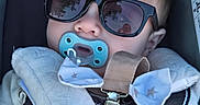 Theo joined the competition — help win amazing prizes! accessory, baby, black, blue, car_seat, child, closeup, clothing, comfort, cute, face, head, infant, pacifier, reflection, seatbelt, soft, star_pattern, strap, sunglasses
