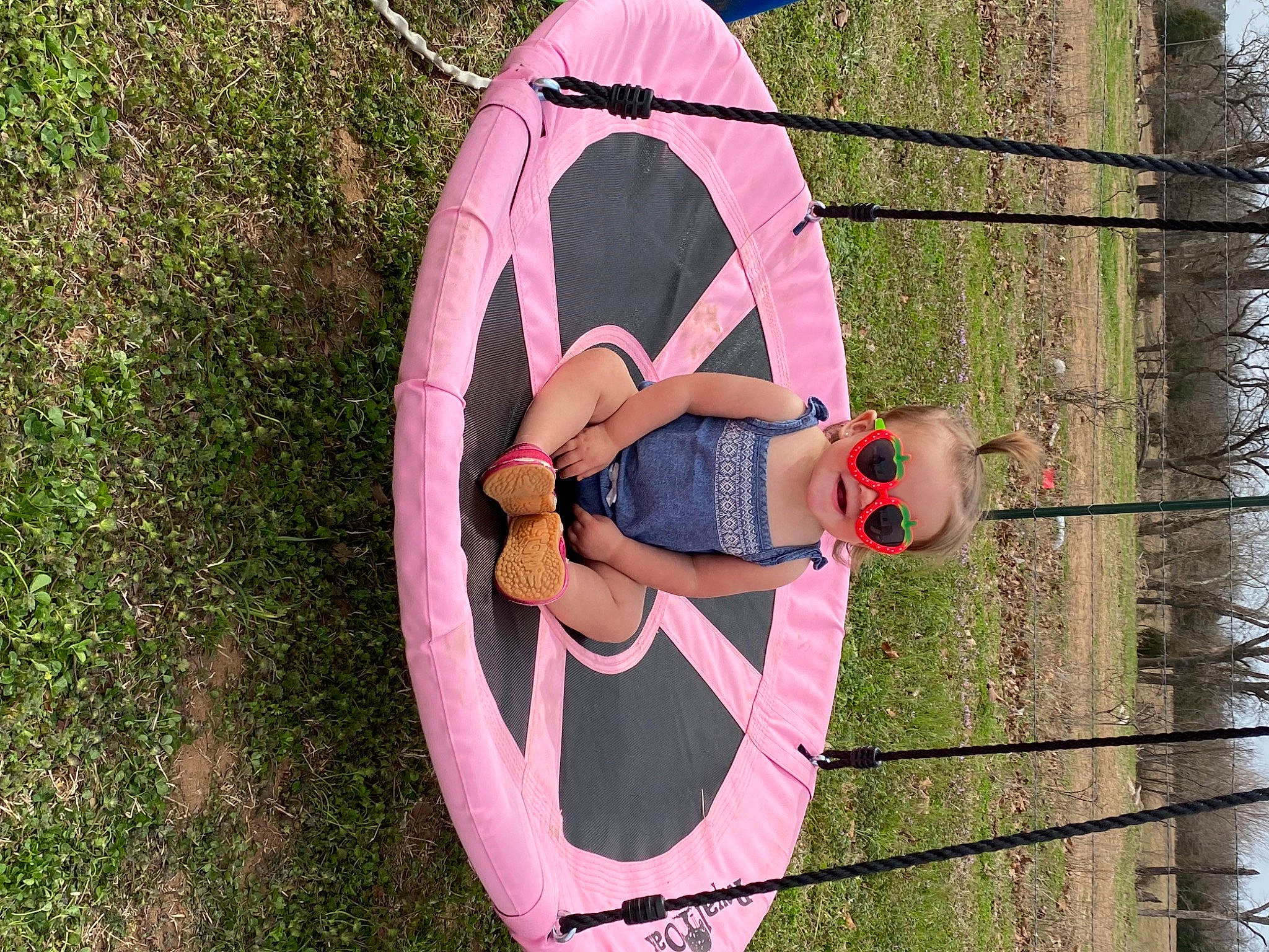 Emma Grace is registered to the contest to win money with this photo: adventure, automotive_wheel_system, child, circle, font, fun, grass, happy, hat, leisure, magenta, outdoor_play_equipment, person, pink, plant, recreation, spring, swing, tree, wheel