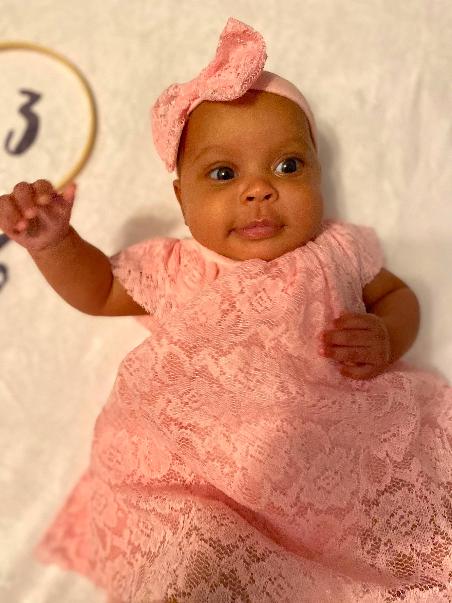 Annalise is registered to the contest to win money with this photo: baby, baby_toddler_clothing, cheek, child, chin, dress, eye, face, finger, gesture, happy, head, headgear, headwear, human_body, lip, nose, person, pink, skin