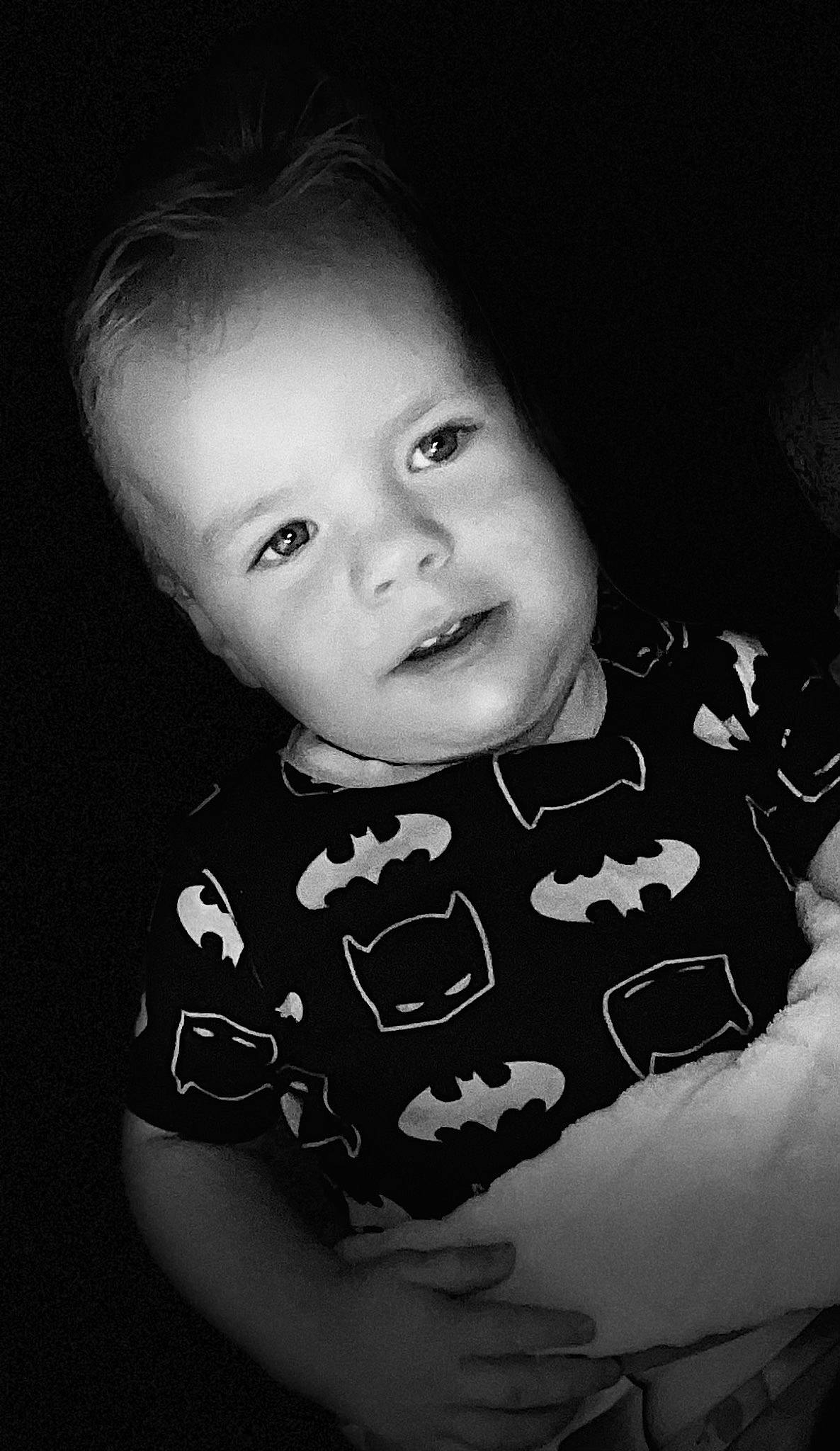 Asher is registered to the contest to win money with this photo: baby, black_and_white, black_hair, cheek, eye, flash_photography, gesture, happy, iris, jaw, lip, mouth, nose, person, skin, sleeve, smile, standing, style, toddler