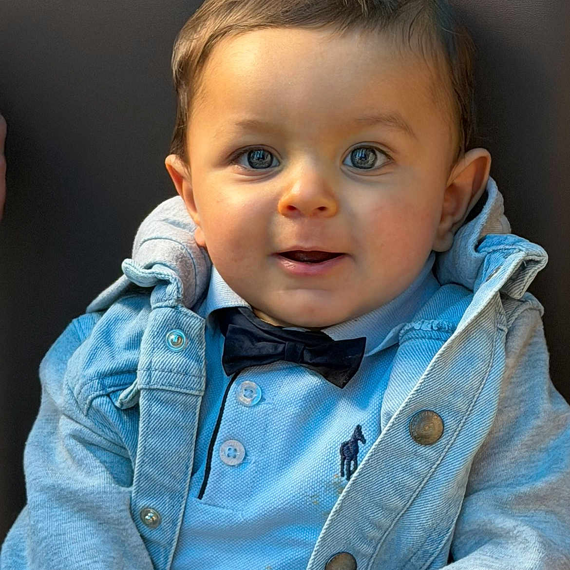Maylon participe au concours pour gagner de l'argent avec cette photo : baby, child, face, blue_shirt, bow_tie, denim_jacket, cute, portrait, smiling, happy, young_child, buttoned_shirt, clothing, sitting, indoors, person, head_and_shoulders, casual_wear, closeup, infant