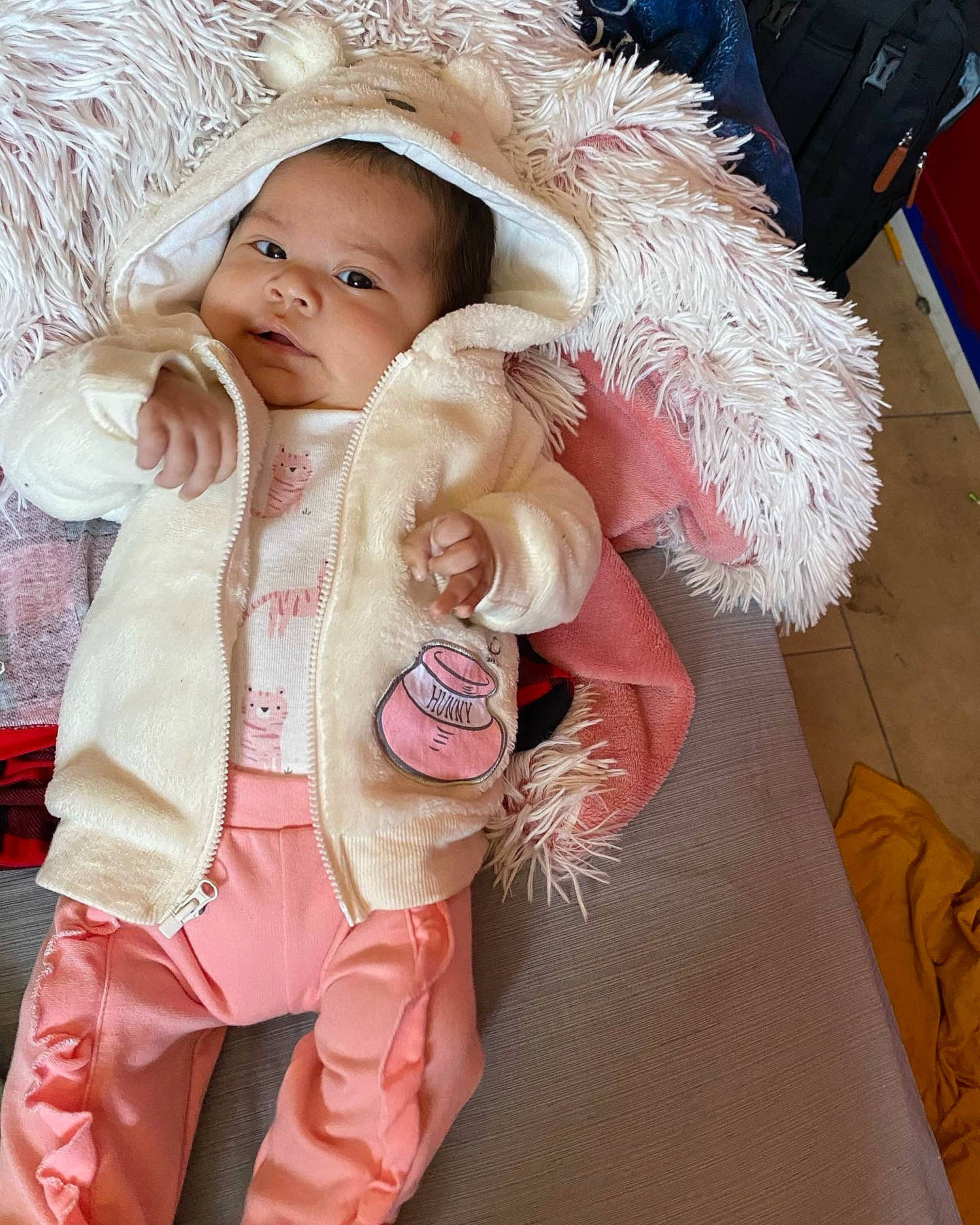 Esther is registered to the contest to win money with this photo: baby, baby_toddler_clothing, cap, child, costume, fashion_accessory, fur, fur_clothing, happy, headgear, linens, magenta, peach, person, pink, skin, sleeve, smile, toddler, white