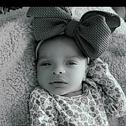 Amira is registered to the contest to win money with this photo: baby, infant, headband, bow, floral_pattern, blanket, texture, portrait, clothing, face, newborn, sleepy, cute, soft, resting, black_and_white, closeup, child, baby_girl, cozy