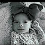baby, infant, headband, bow, floral_pattern, blanket, texture, portrait, clothing, face, newborn, sleepy, cute, soft, resting, black_and_white, closeup, child, baby_girl, cozy