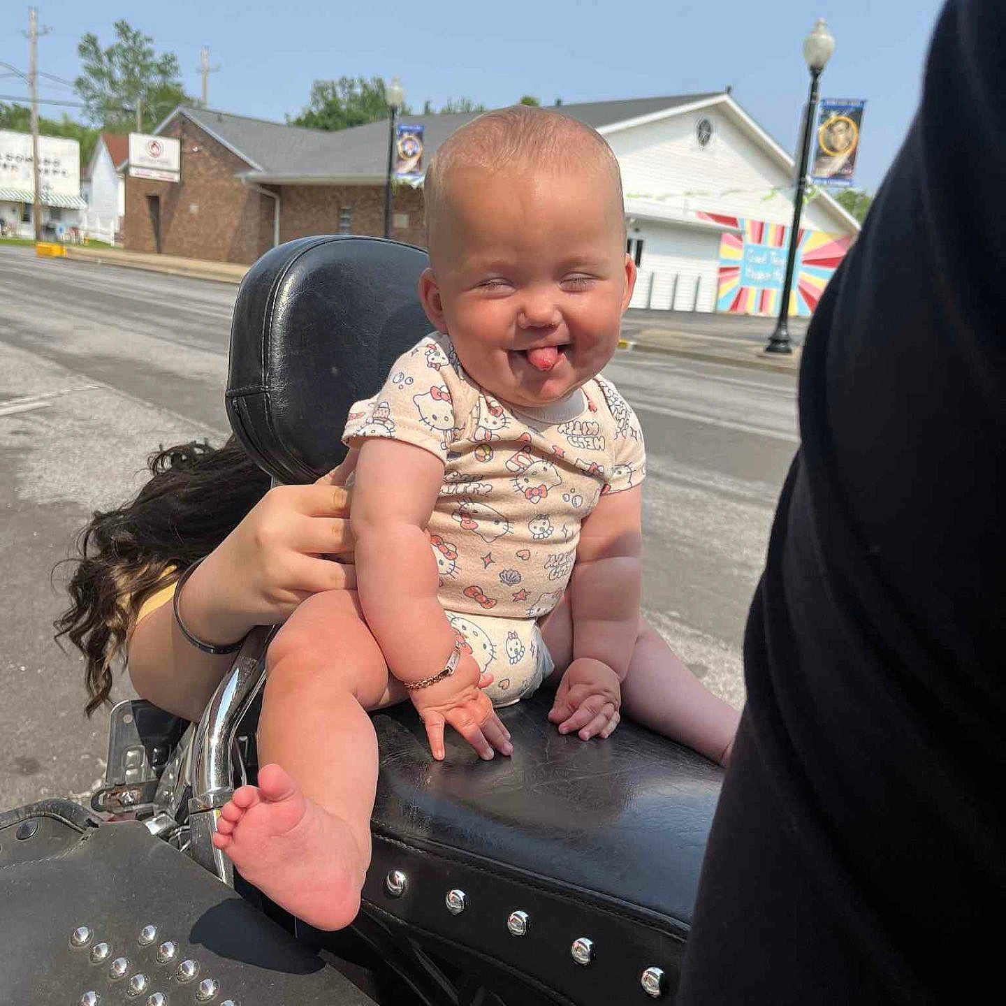 Zyalani joined the competition — help win amazing prizes! baby, bracelet, building, child, clothing, cute, daytime, expression, funny_face, hand, holding, humor, motorcycle, outdoor, person, road, seat, sky, tongue_out, urban