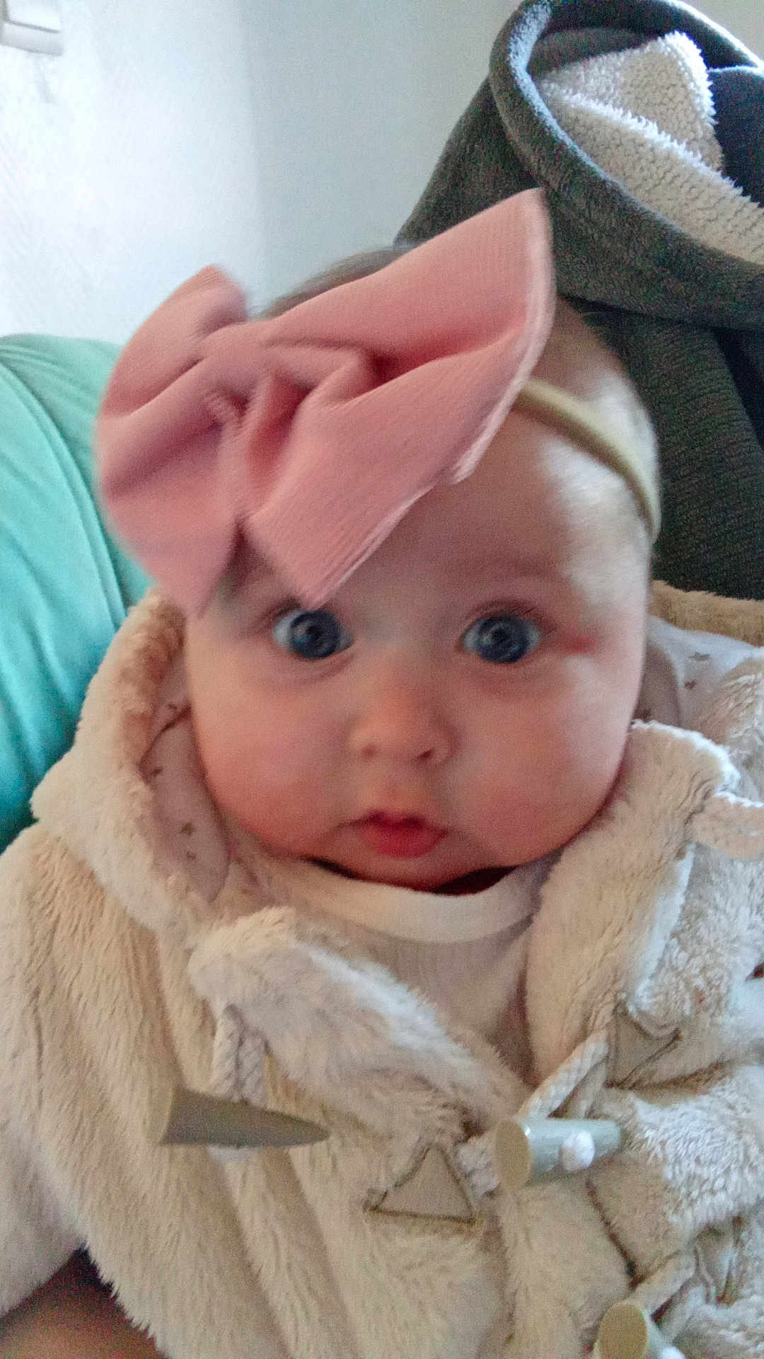Thalya participe au concours pour gagner de l'argent avec cette photo : baby, infant, face, headband, pink_bow, coat, fluffy_clothing, blue_eyes, indoor, person, child, cute, expression, portrait, warm_clothing, newborn, soft_texture, closeup, adorable, cozy