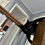 black_cat, cat, indoor, railing, wood, doorway, curious, house, pet, animal, wide_eyes, feline, looking, home_interior, stairs, baluster, playful, domestic_cat, wooden, door