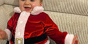 Eden participe au concours pour gagner de l'argent avec cette photo : baby, cheerful, child, couch, cozy, cute, festive, furniture, happy, holiday, indoor, infant, person, plush, portrait, red_clothing, santa_costume, seated, smiling, white_fur_trim